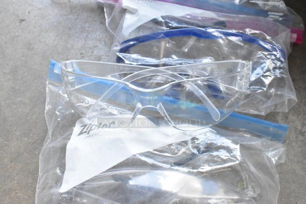 High visibility vests, hard hats, and safety glasses in poly bin, in good condition. Ziploc bags visible.