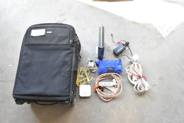 Think Tank soft bag with assorted contents, including cables, power adapters, and a blue pouch; tag reads "242".