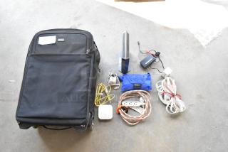 Think Tank soft bag with assorted contents, including cables, power adapters, and a blue pouch; tag reads "242".