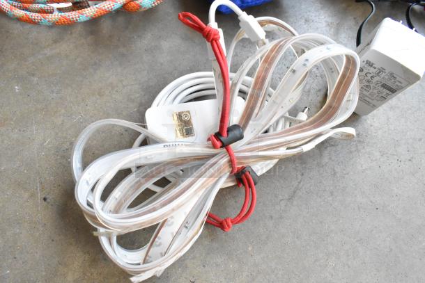 Think Tank soft bag contents with coiled power cables and adapters, including Philips charger, organized with red ties.