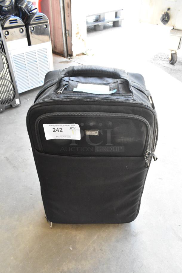 Think Tank soft bag with contents, black color, zippered pockets, handle on top, label indicating auction item 242.