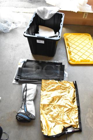 Hard poly bin with Westcott fabric contents, including black and gold fabric sheets, label "243," yellow lid beside.