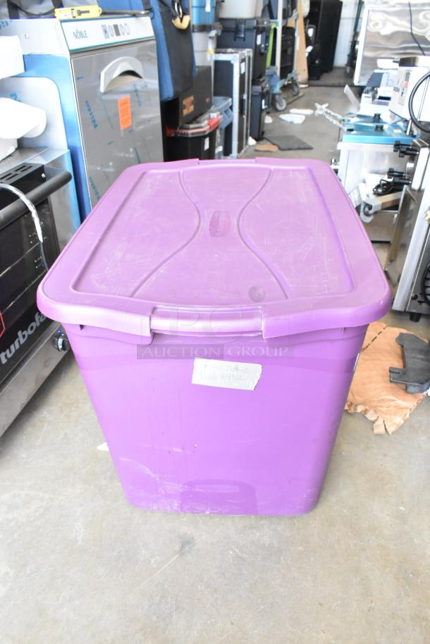 Purple storage bin labeled "Future Clothes," containing a variety of hard cases. Bin shows light wear.