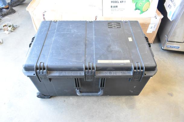 Black hard case for Freefly Mavi M10 gimbal, model M10B22910. Case shows signs of wear. Labels and latches visible.