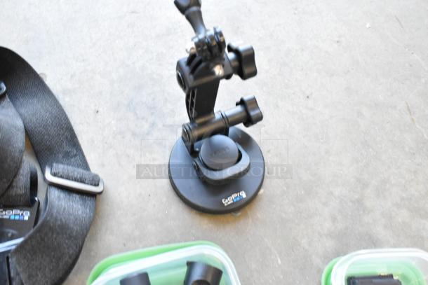 Lot of various items including GoPro accessories, wires, poly containers in poly bin. Features mounts and straps.