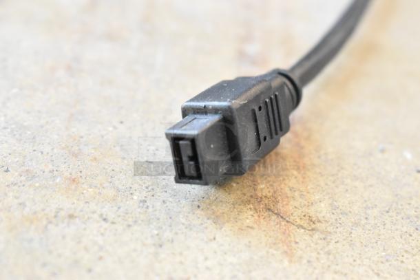 Close-up of a black electrical connector with a rectangular end, part of a lot including various wires in a poly bin.
