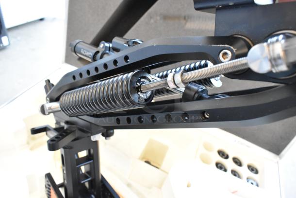 Flowcine Black Mount with black steel springs in hard case. Features adjustable rods and labeled components. Excellent condition.