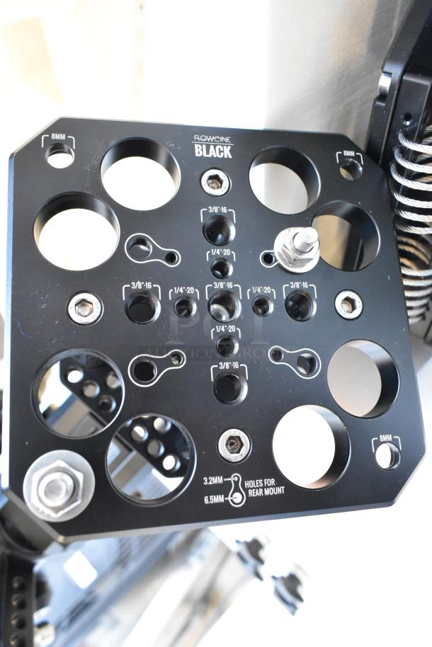 Flowcine Black Mount with multiple threaded holes, marked with sizes, in excellent condition within a protective hard case.