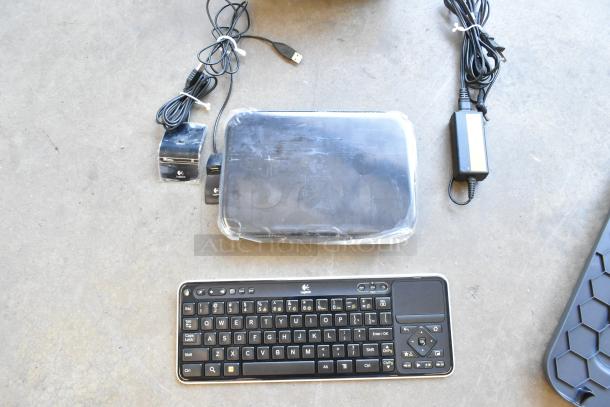 Logitech Revue media player with keyboard and cables, minor wear, includes power adapter and USB cable.