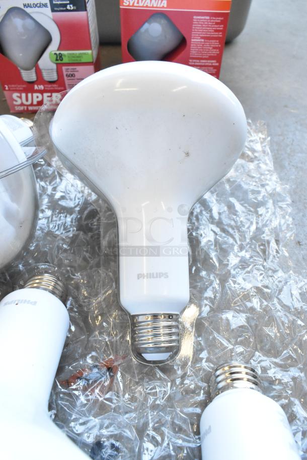 Lot of Sylvania lightbulbs in original packaging with visible Philips branding; variety of bulb types and conditions.