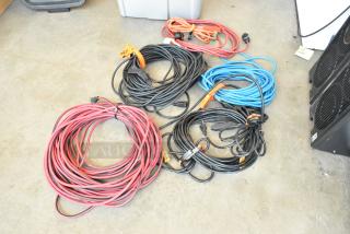 Lot of extension cords in poly bin, various colors and lengths, includes red, black, and blue cords; good condition.