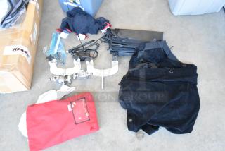 Lot of various items including metal holder for fabric, bundled in a poly bin; features some packaging and miscellaneous fabrics.