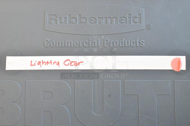 Rubbermaid Commercial Products container with "Lighting Gear" label in red ink on a strip, placed on the lid.