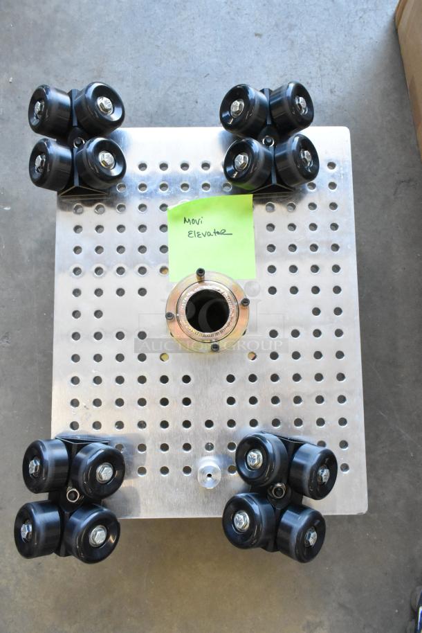 Movi Elevator with metal perforated plate and rubber wheels, in good condition. Green label marked "Movi Elevator."