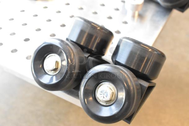 Movi Elevator component with black wheels on metallic base, showing hex bolts. Ideal for precise equipment movement.