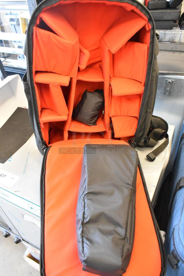 Two bags, including Porta Brace and Petrol Bags, with orange padded interiors, adjustable sections, and black exterior, in good condition.