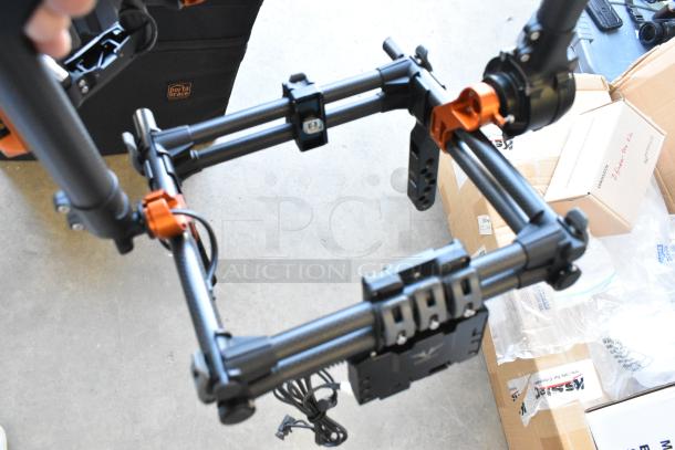 Digi Ignite metal frame with black and orange components, shown in excellent condition, includes Porta Brace rolling bag.