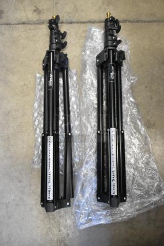 Two Westcott Basics Stands, black, compact design, with adjustable height. Labeled with contact information. Good condition.