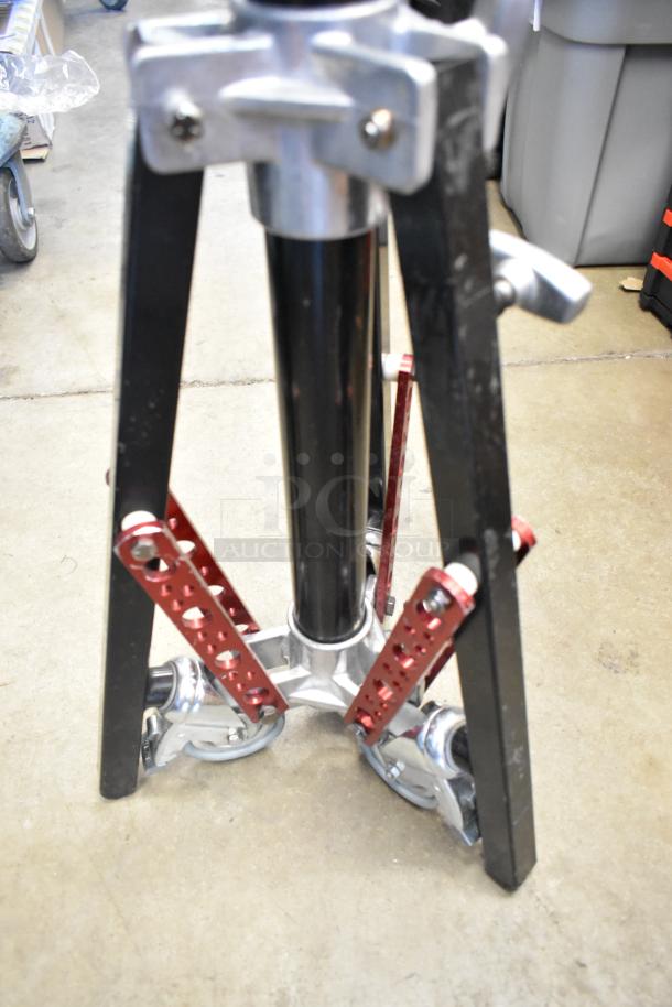 Matthews Tripod with chrome and black finish, sturdy base, red adjustment levers, and wheels. Excellent condition.