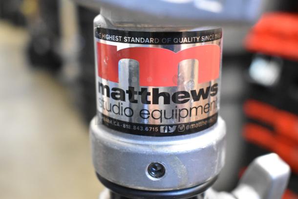 Matthews studio tripod with visible branding label. High-quality metal construction, in good condition, ideal for professional use.