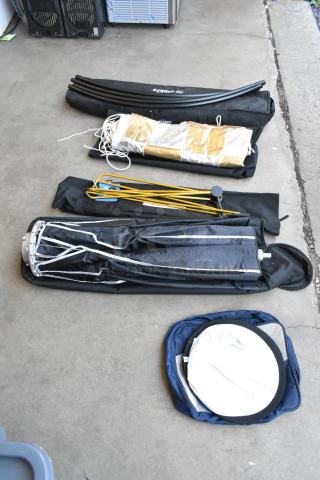 Umbrella and lighting gear set includes fabric holder, stands, and accessories. Items are in good condition, various colors.