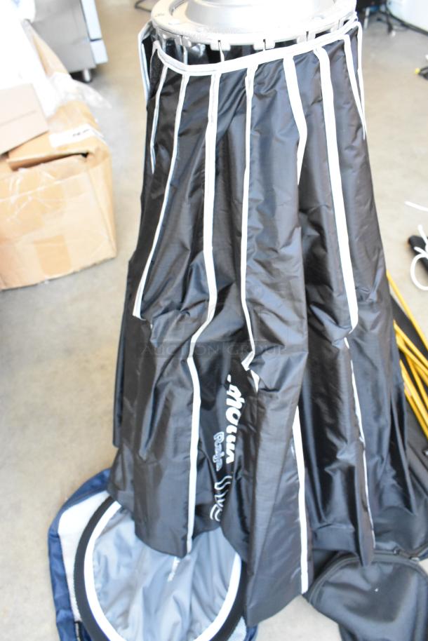 Black fabric light umbrella with white trim, featuring a sturdy metal frame and carrying case. Includes lighting gear, in good condition.