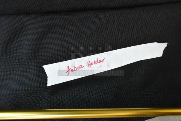 Fabric holder photography gear, featuring a label marked “Fabric Holder” on a black fabric background.