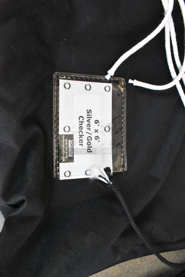 Fabric holder for lighting gear with a label indicating 6' x 6' Silver/Gold Checker pattern by Modern Studio Equipment.