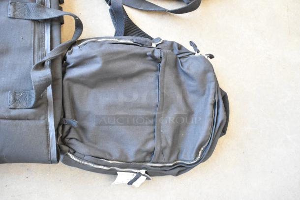 Lot of 4 black soft bags, gently used, with zippers and handles, suitable for various uses. Includes visible tags.