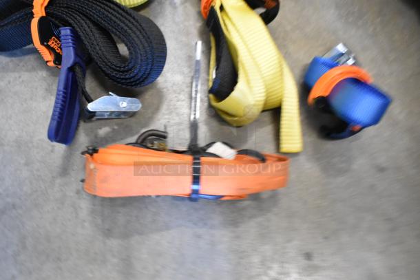 Lot of assorted ratchet straps in various colors, including orange, black, yellow, and blue, bundled in a poly bin.