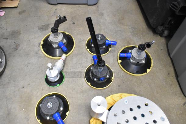 Lot of metal parts in a poly bin on concrete floor, featuring pipe connectors and fittings with blue and yellow accents.