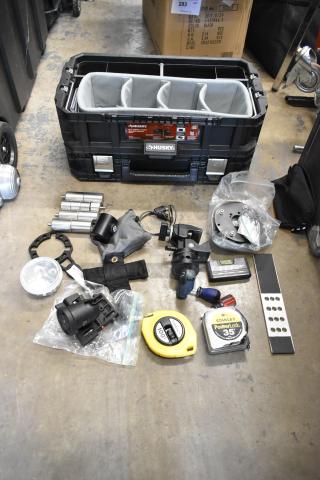 Lot of various items in a Husky tool box including Giottos MH7001, Mitchell wrench, and Stanley tape measures.