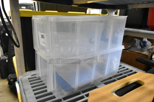 Clear poly bins, stackable, labeled "285," in excellent condition on a shelf. Auction: 2x your bid.