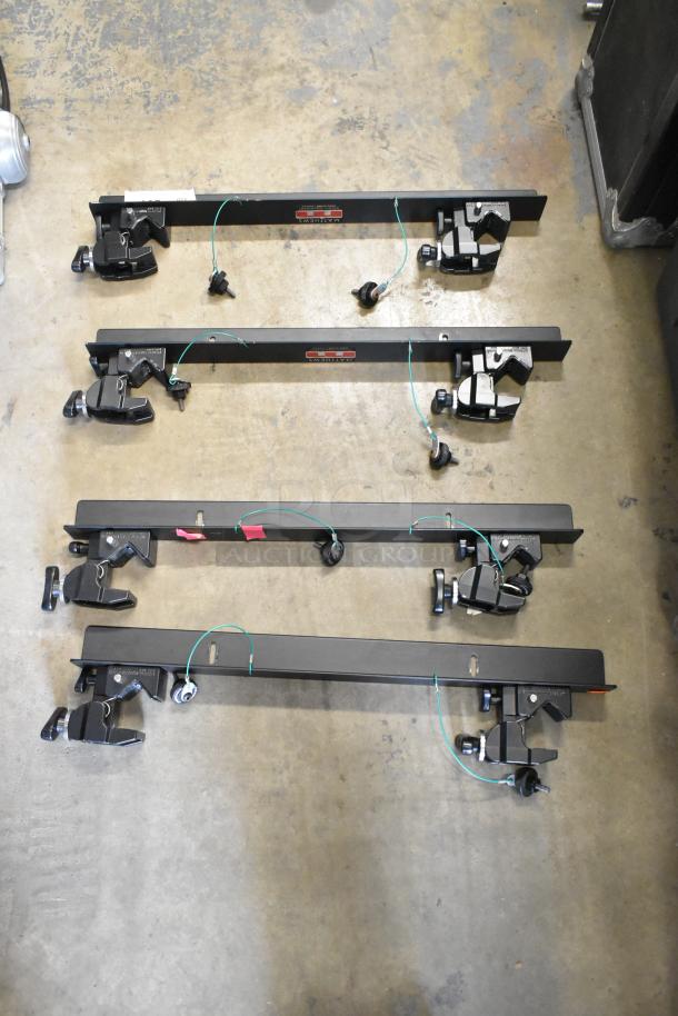Four Matthews Studio Equipment frames, black metal, clamps attached, good condition.