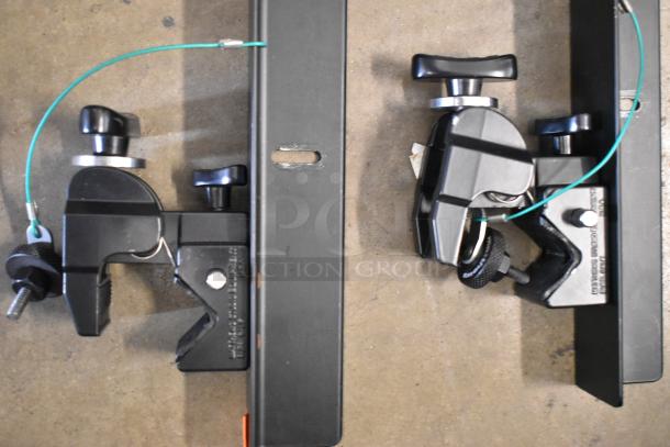 4 Matthews Studio Equipment clamps, black metal, excellent condition, securing frame with green cable for stability.