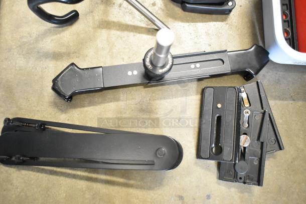 Various metal and plastic parts in a poly bin, featuring adjustable brackets and a knob, in good condition.