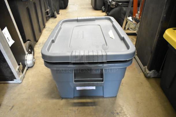 Gray poly bin containing various parts and pieces, marked with "Rubbermaid" on the lid, in good condition.
