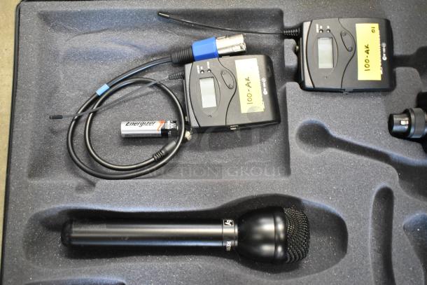 2 Sennheiser SK100 bodypack transmitters in foam case, with cables and battery. Each with label "100-AK".