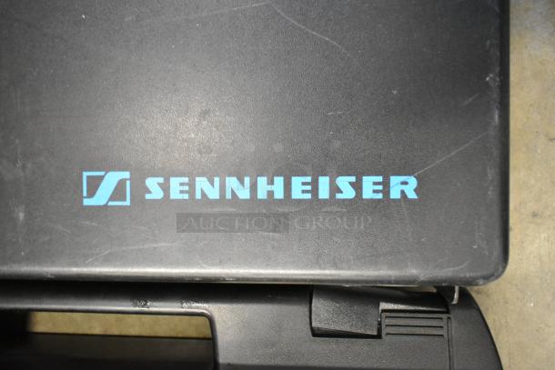 Two Sennheiser SK100 bodypack transmitters with Sennheiser logo on a case. Appears used, suitable for professional audio use.