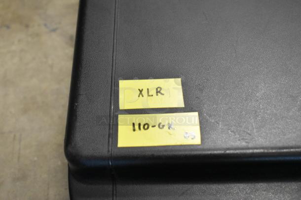 Two yellow tape labels on a black case. Top label reads "XLR," bottom label "110-GK 03."