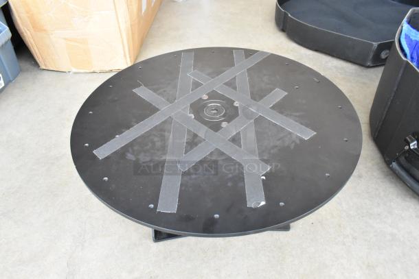 Round black SKB unit with cross tape pattern, visible rivets, and central mounting point. Appears in good condition.