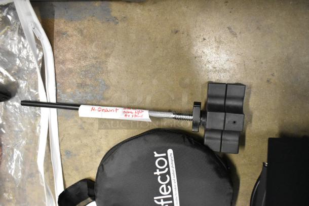 Lot of photography equipment including a Westcott reflector, snoot, M-Q mount, and umbrella reflector, with visible labels.