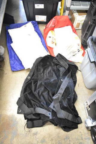 Various fabrics in poly bin; includes black, white, blue, red materials with grommets; used condition; HDX storage bin visible.