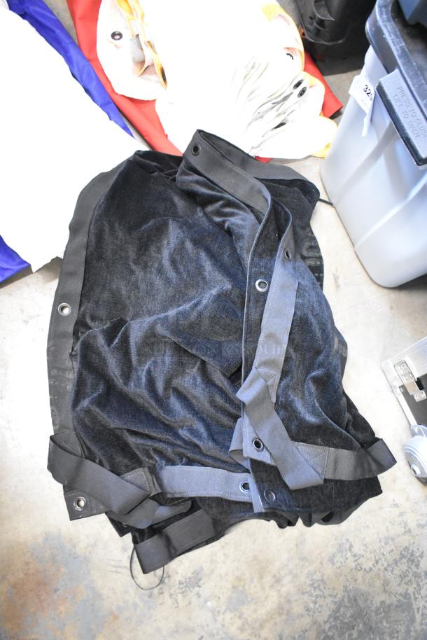 Various black fabric pieces with grommets and straps in poly bin, showing mixed materials and potential for crafting or repairs.