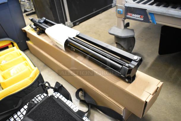 Lot of various items including an Impact light stand, lightbulb, and fabric. Items are packed in a poly bin.