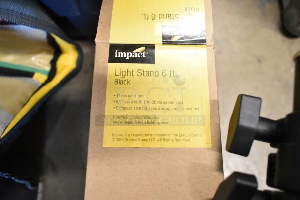 Lot with Impact Light Stand, 6 ft Black, three sections, 5/8" stud, in poly bin. Includes lightbulb and fabric. Good condition.