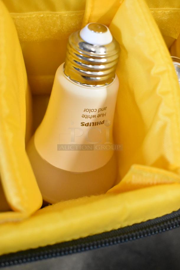 Philips Hue White and Color LED bulb inside poly bin with yellow fabric compartments, part of auction lot.
