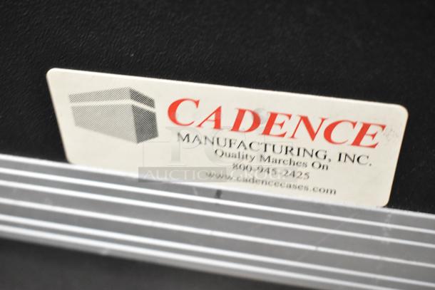 Cadence hard case with label, featuring Cadence Manufacturing, Inc. contact info and logo. Sturdy black exterior.