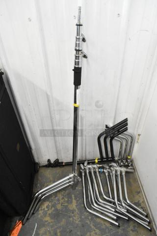 Lot of collapsible tripod pieces, metal construction, multiple rods and fittings, used condition, stacked in storage space.