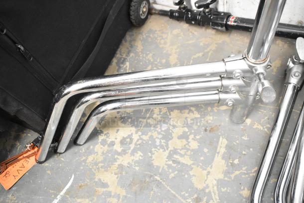 Lot of collapsible tripod pieces, chrome finish, includes three legs and adjustment knobs. Visible tag labeled "heavy."